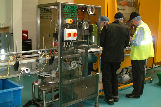 Two men providing maintenance to a conveyor system